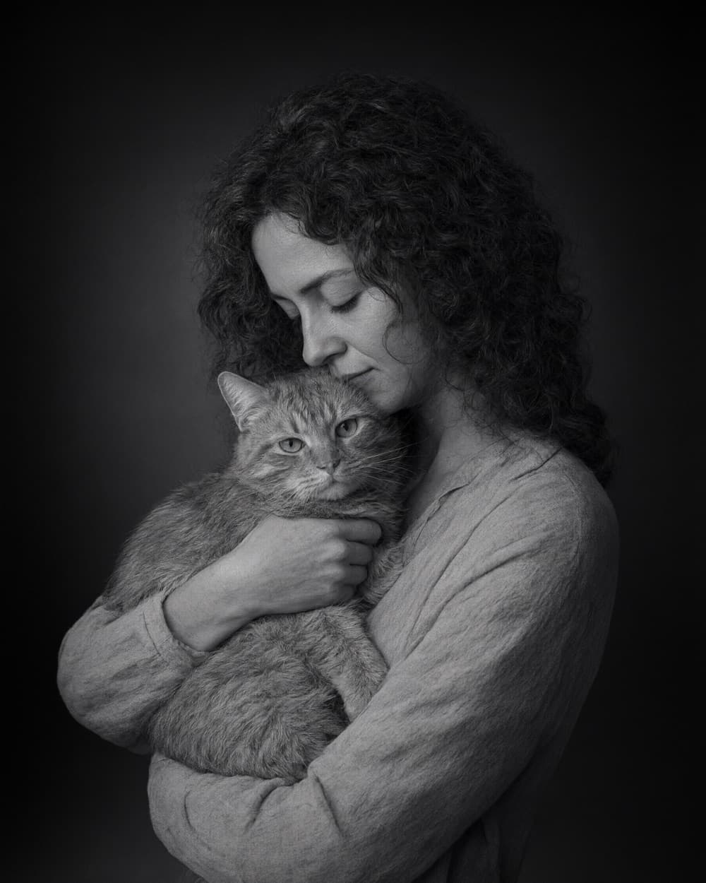 Black and white portrait of a woman holding her cat close